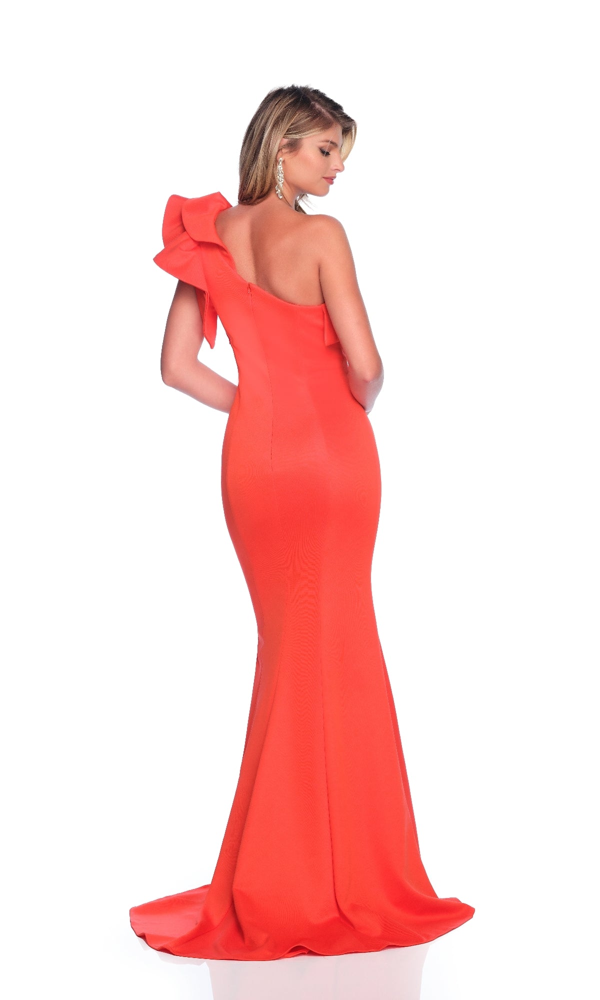 A woman in the Dave & Johnny 12234 one-shoulder, floor-length prom dress with a large shoulder bow stands against a white background, looking to her left.